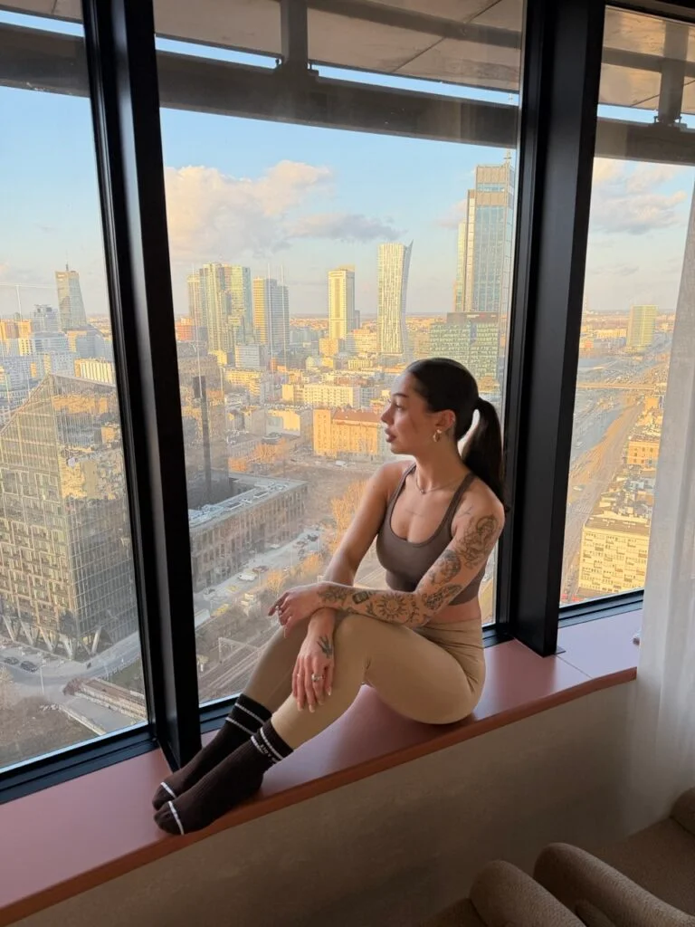Klientka BeShaped przy panoramicznym oknie 24. piętra Atlas Tower